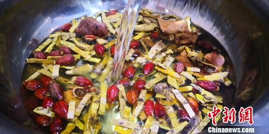 图为精选当地的优质中草药浸泡水煮。　魏建军 摄