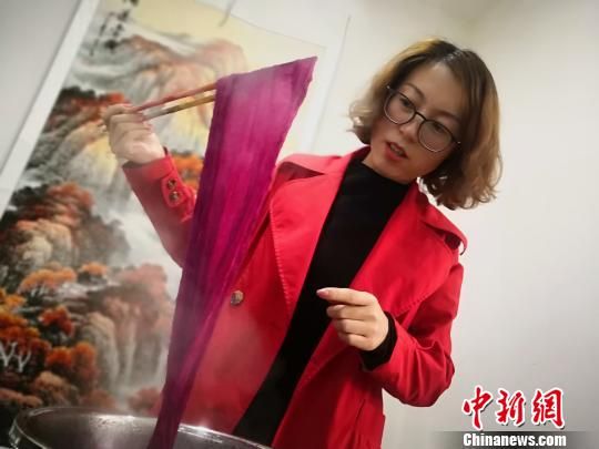 图为祁辉水煮“提炼”中草药色素给丝巾上色。　魏建军 摄