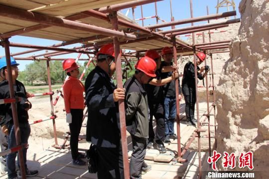 图为设计、施工、监理单位现场探讨破城子遗址保护修复问题。　王建荣 摄