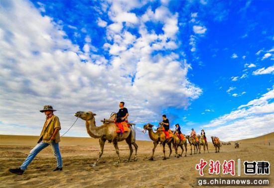 6月中下旬以来，国际旅游名城甘肃敦煌连降小雨，雨过天晴后的鸣沙山月牙泉景区蓝天、白云、黄沙相映成趣，每天吸引大批游人登上鸣沙山观赏大漠落日，陶醉在大漠沙海、夕阳如画的美景之中。(资料图) 王斌银 摄