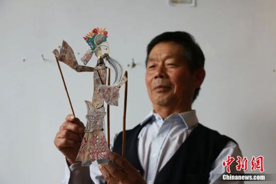 通渭影子腔传承人刘国天向记者展示影件。张婧 摄
