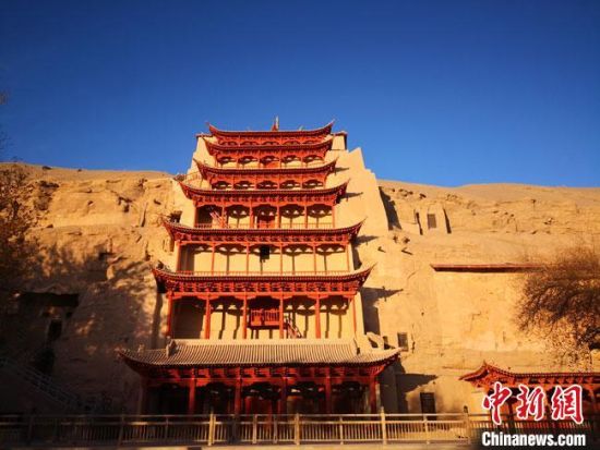图为11月初,沐浴在晨光中的世界文化遗产敦煌莫高窟标志性建筑“九层楼”。 冯志军 摄 图为11月初,沐浴在晨光中的世界文化遗产敦煌莫高窟标志性建筑“九层楼”。 冯志军 摄