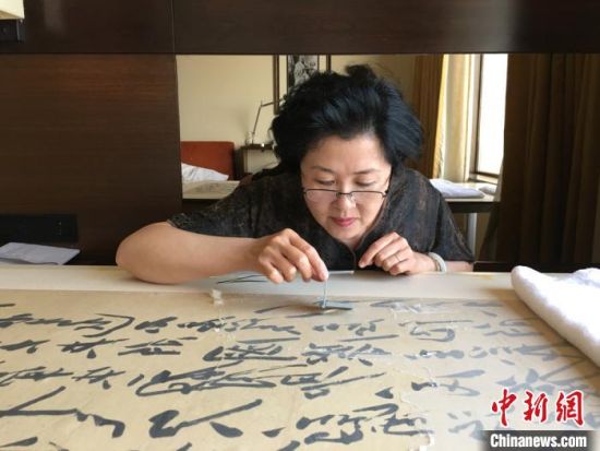 　图为赵莉修复工作。(资料图)受访者供图