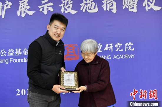 12月11日,敦煌研究院榆林窟保护展示设施捐赠仪式在榆林窟举行。敦煌研究院名誉院长樊锦诗(右)先生向国强公益基金会颁发了捐赠证书。敦煌研究院供图 12月11日,敦煌研究院榆林窟保护展示设施捐赠仪式在榆林窟举行。敦煌研究院名誉院长樊锦诗(右)先生向国强公益基金会颁发了捐赠证书。敦煌研究院供图