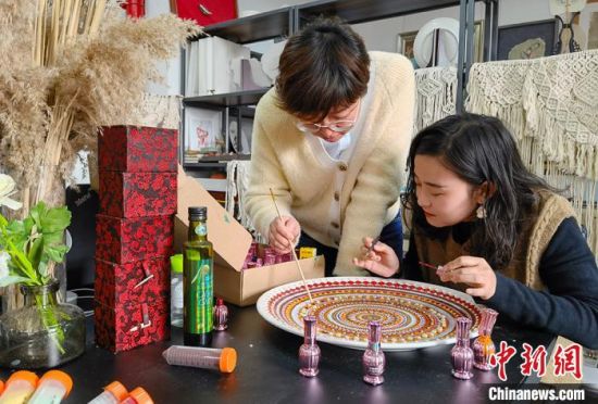 图为老师指导学生制作敦煌彩绘工艺盘。 刘玉桃 摄 图为老师指导学生制作敦煌彩绘工艺盘。 刘玉桃 摄