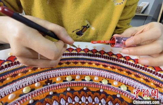 图为学生用指甲油创作敦煌彩绘工艺盘。 刘玉桃 摄 图为学生用指甲油创作敦煌彩绘工艺盘。 刘玉桃 摄