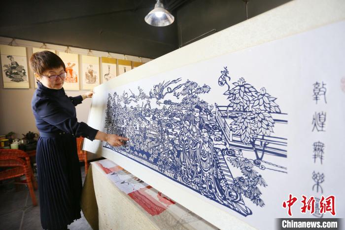 4月下旬,庄生娟向记者介绍耗时两个月的剪纸作品《敦煌舞乐图》。 高展 摄 4月下旬,庄生娟向记者介绍耗时两个月的剪纸作品《敦煌舞乐图》。 高展 摄