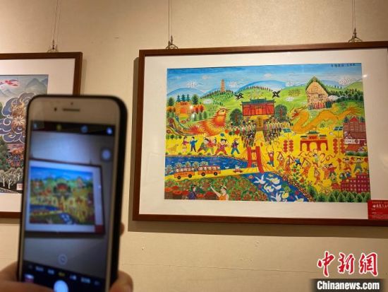 农民艺术家用画笔真实记录家乡的点滴，反映了农村变化和农民幸福生活。　徐雪 摄