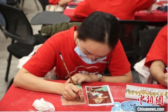 图为青年学子体验敦煌泥版画，了解敦煌壁画制作工艺。　信晓泽 摄