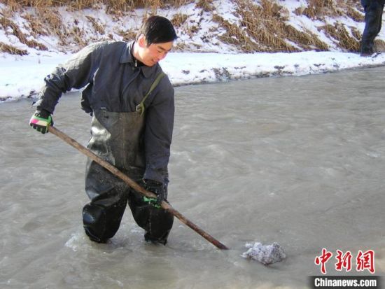 2003年冬季，为防止冰凌危害文物安全，杜建君参与在榆林河道内清理冰凌。(资料照片) 敦煌研究院供图