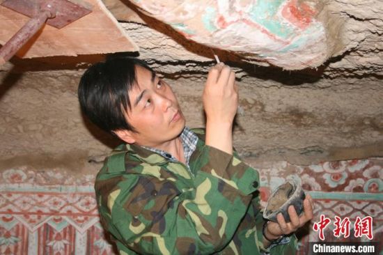 图为2005年杜建君在洞窟内工作。(资料照片) 敦煌研究院供图