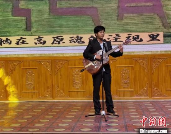 图为刘雷手抱吉他，在舞台上演唱自创歌曲《忆羚》。(资料图) 张婧 摄