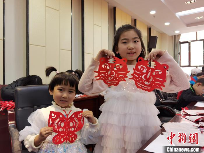 图为兰州孩童展示剪纸作品《小老虎》《蝴蝶》。 徐雪 摄 图为兰州孩童展示剪纸作品《小老虎》《蝴蝶》。 徐雪 摄