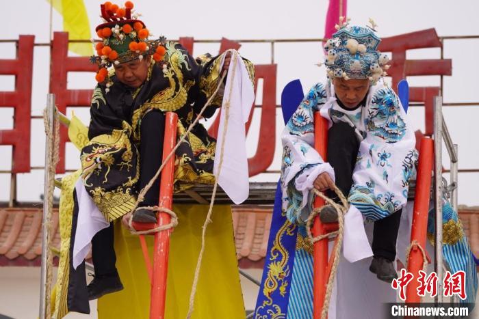 图为“苦水高高跷”表演者通过麻绳将脚固定在脚踏板,并在腿部缠绕六七圈。 九美旦增 摄 点击进入下一页