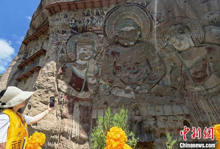 图为游客游览拉梢寺摩崖大佛。 刘玉桃 摄 图为游客游览拉梢寺摩崖大佛。 刘玉桃 摄
