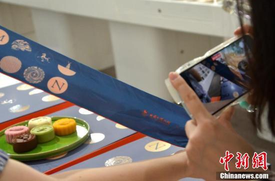 8月24日,甘肃省博物馆内参观者正在拍摄文创月饼包装盒上的手提丝带,该手提丝带也是一条文创丝巾。 李亚龙 摄 8月24日,甘肃省博物馆内参观者正在拍摄文创月饼包装盒上的手提丝带,该手提丝带也是一条文创丝巾。 李亚龙 摄