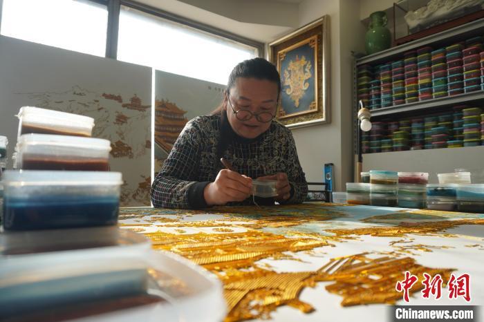 李海明在工作室内精心制作掐丝珐琅画。 九美旦增 摄
李海明在工作室内精心制作掐丝珐琅画。 九美旦增 摄