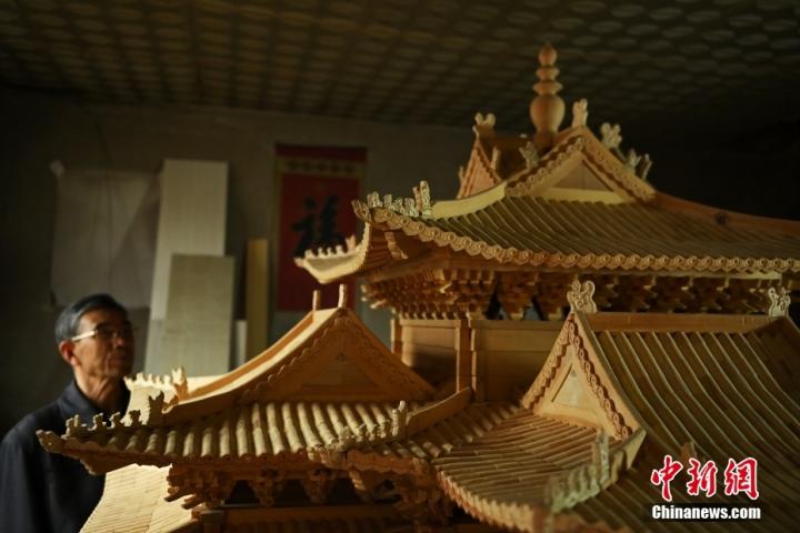 6月27日,甘肃省金昌市永昌县一民居内,年过七旬的古建筑营造技艺“守”艺人杨万年观察自己制作的微缩版北京故宫角楼。 6月27日,甘肃省金昌市永昌县一民居内,年过七旬的古建筑营造技艺“守”艺人杨万年观察自己制作的微缩版北京故宫角楼。