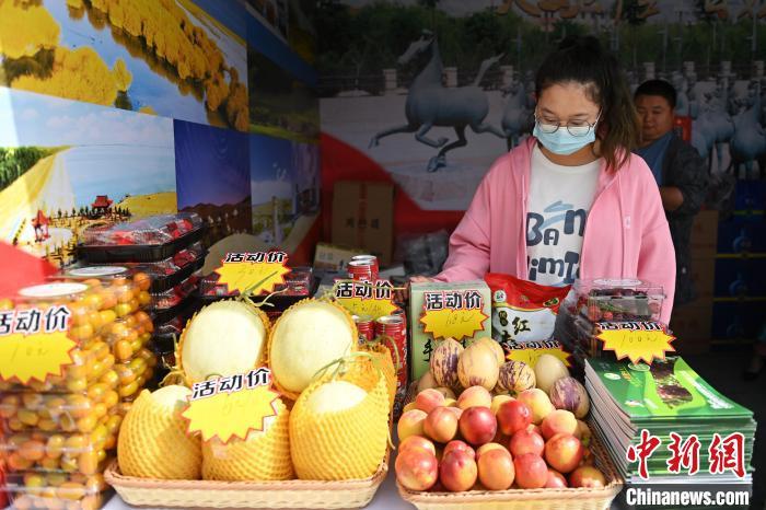 图为活动现场工作人员推荐武威特色产品。　李亚龙 摄