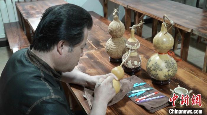 图为临夏雕刻葫芦州级传承人白正兵正在雕刻葫芦作品。田鹏鹤 摄 图为临夏雕刻葫芦州级传承人白正兵正在雕刻葫芦作品。田鹏鹤 摄