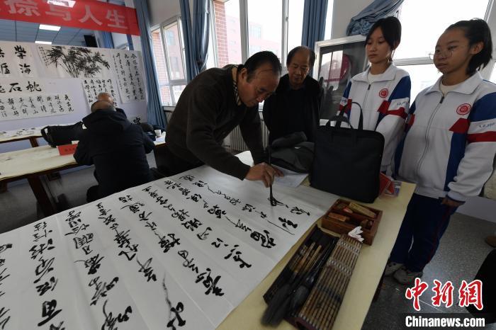 图为书法家在兰州交通大学附属中学现场书法交流。戴文昌 摄 图为书法家在兰州交通大学附属中学现场书法交流。戴文昌 摄