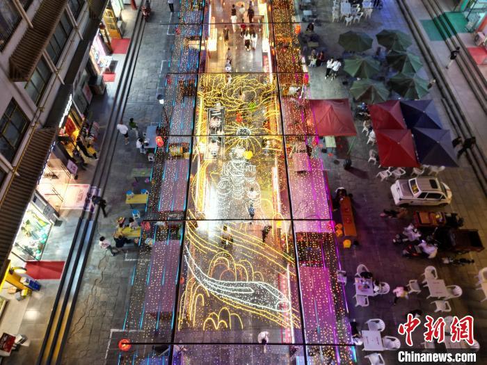 图为明清街夜市灯光点亮具有武威文化元素的“天梯山石窟”彩灯。(无人机照片) 　戴文昌 摄

　　