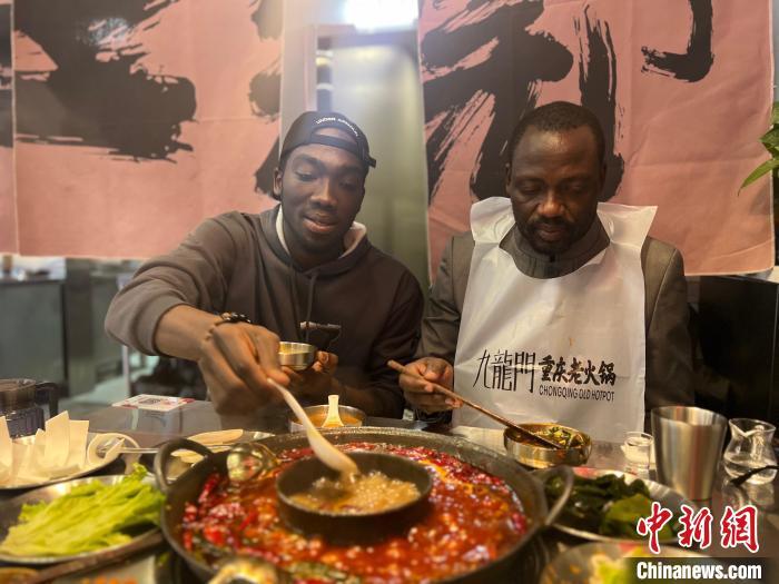 2024年春节期间，来自刚果(布)的留学生马丁(左)带爸爸(右)在兰州吃火锅。受访者供图