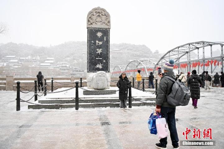 图为市民在兰州标志性建筑中山桥边合影留念。九美旦增 摄