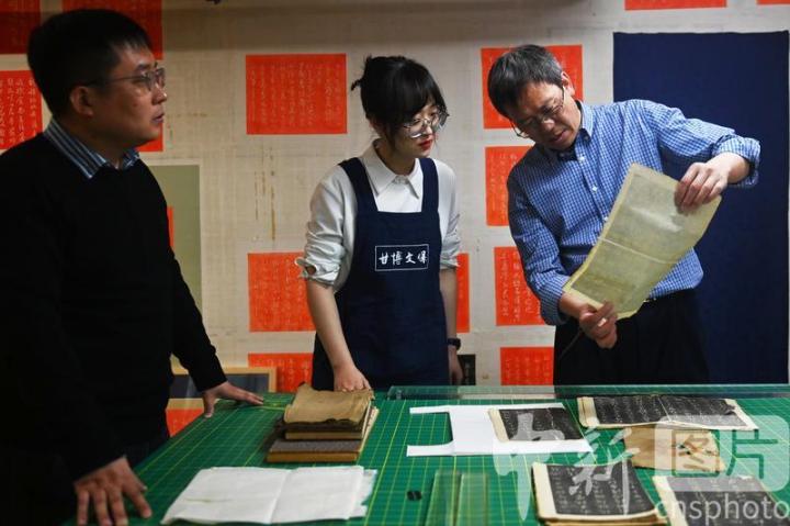 4月26日，甘肃兰州，在甘肃省博物馆文物保护修复中心内，工作人员沟通交流肃府本《淳化阁帖》拓片的传承保护与修复。中新社记者 李亚龙 摄