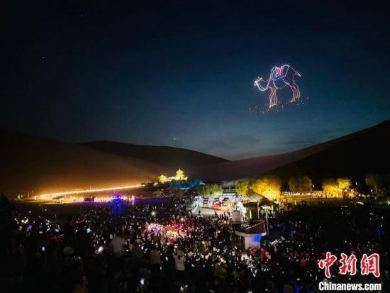 6月15日晚，敦煌鸣沙山，万人星空大漠演唱会启幕。图为无人机秀在月牙泉上空形成骆驼图案。　九美旦增 摄