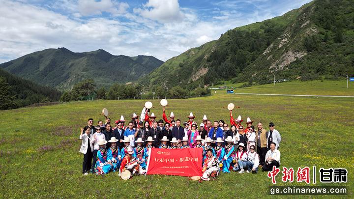 图为华媒代表与身穿民族服饰的舞者在大峪沟景区合影留念。九美旦增 摄