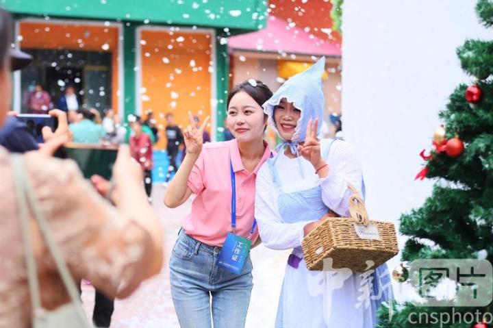 6月27日，位于甘肃省陇南市武都区的五马童话小镇开街运营，参加活动人员(左)与童话人物扮演者(右)合影。