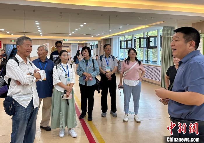 左一为王金城，他正在和兰州一家社区养老中心负责人交流。丁思 摄