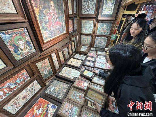图为游客选购图案为莫高窟壁画的泥板画。王牧雨 摄
