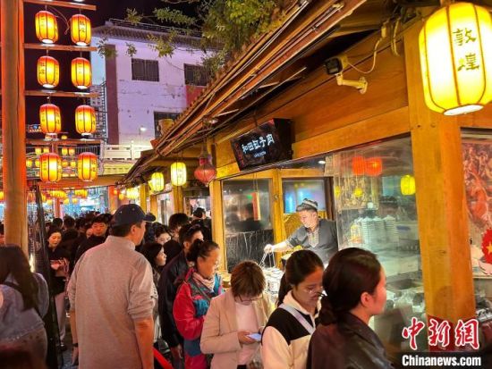 图为游客排队选购特色小吃。王牧雨 摄