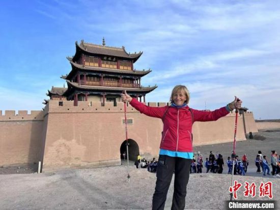 10月15日至28日，维娜在古丝路黄金段甘肃，穿越敦煌、嘉峪关、张掖等地，行至兰州。图为维娜在嘉峪关与关城合影。(甘肃省文化和旅游厅供图)