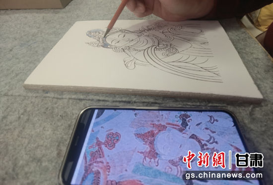 图为留学生给壁画图像填色。