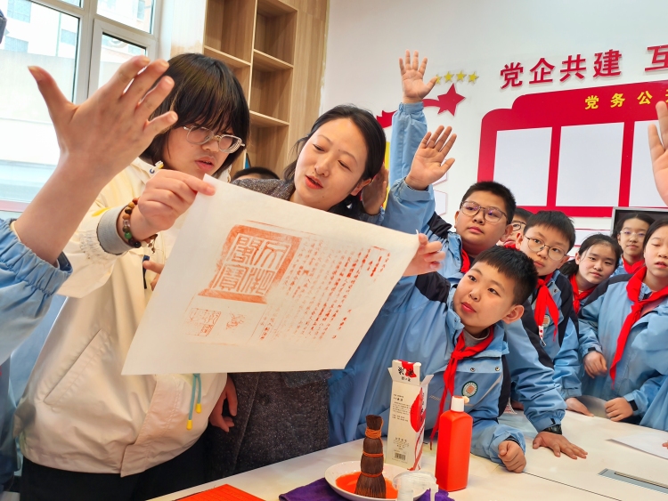“千古巨制——《四库全书》展”亮相兰州市学府致远学校_fororder_学生在老师的指导下体验