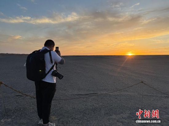 图为游客在景区内拍摄落日。