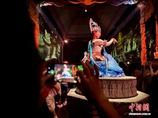 图为演出中观众拍摄演员表演。王牧雨 摄